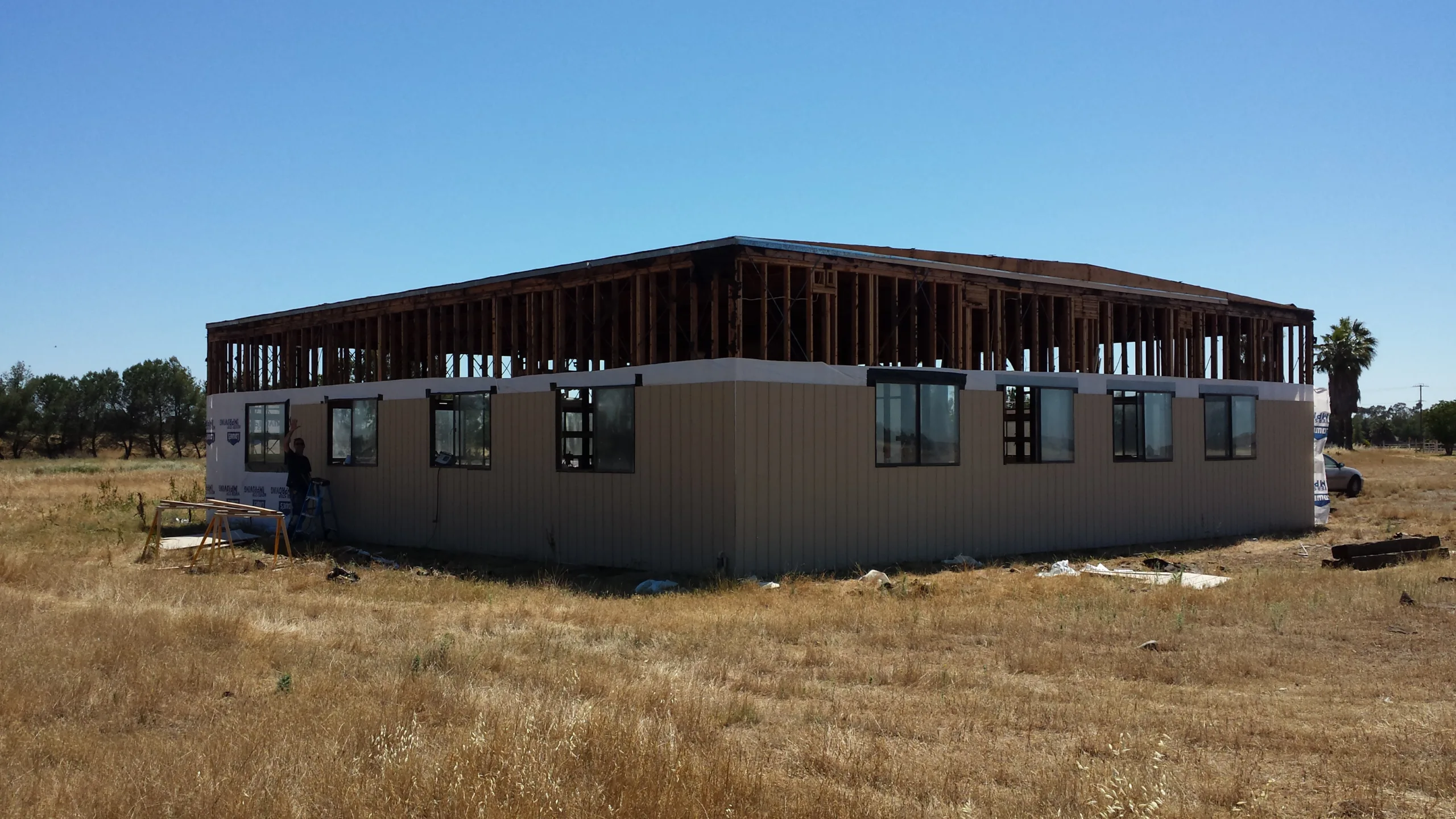 A house is being built in the middle of a field.